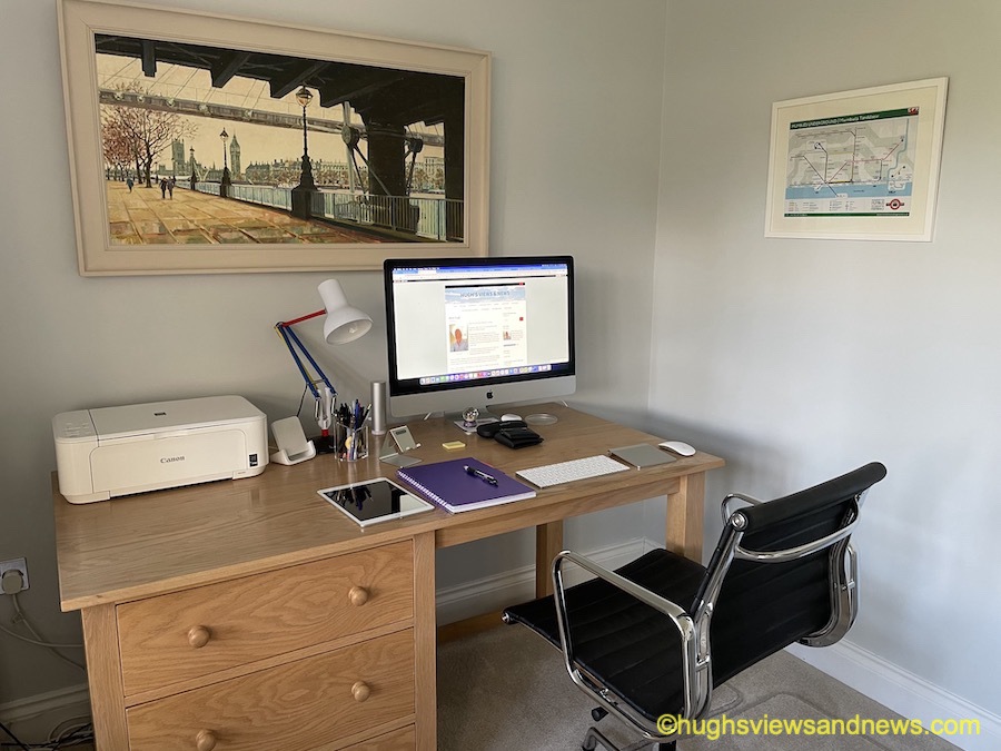 Photo showing Hugh's desk with a computer screen showing Hugh's home page of his blog.