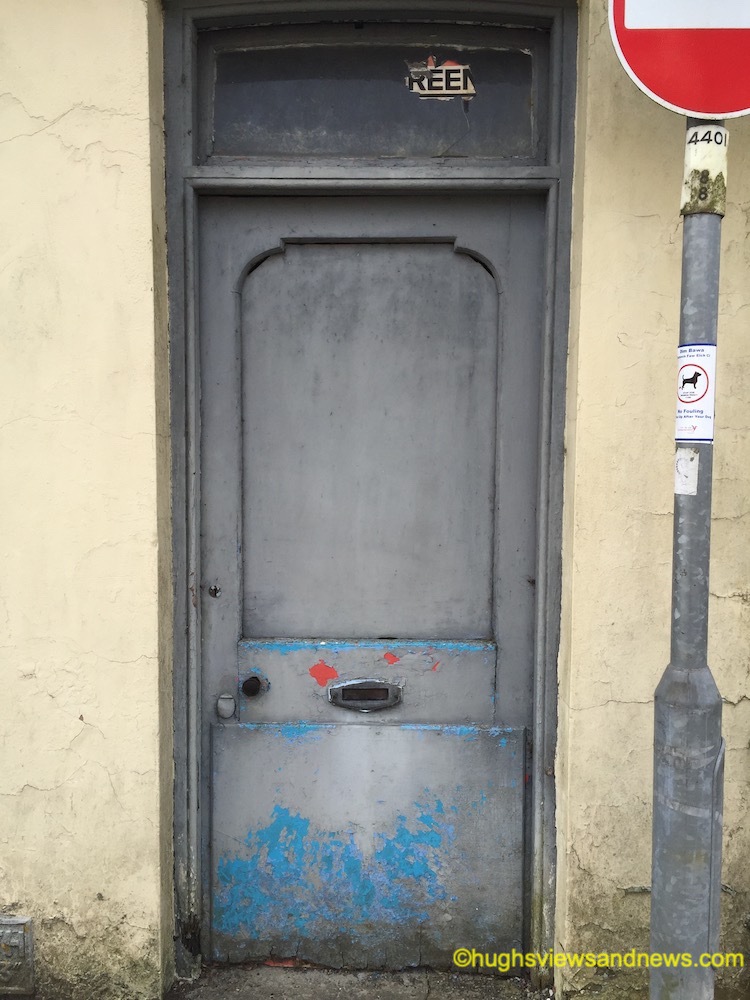 Photo of a scruffy door in need of a lot of repairs. 