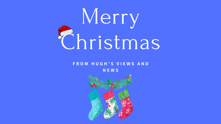 Blue image with the words 'Merry Christmas From Hugh's Views And News' in white text. A Santa hat sits on the letter 'C' and three Christmas stockings hang on a festive garland.