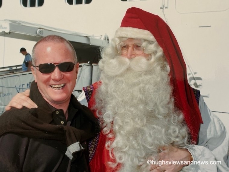 A photo of a smiling man standing next to Father Christmas